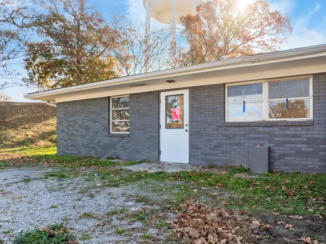 a view of a brick house next to a yard