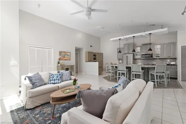 a living room with furniture kitchen view and a chandelier