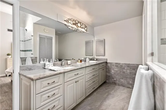 a bathroom with a granite countertop sink mirror and