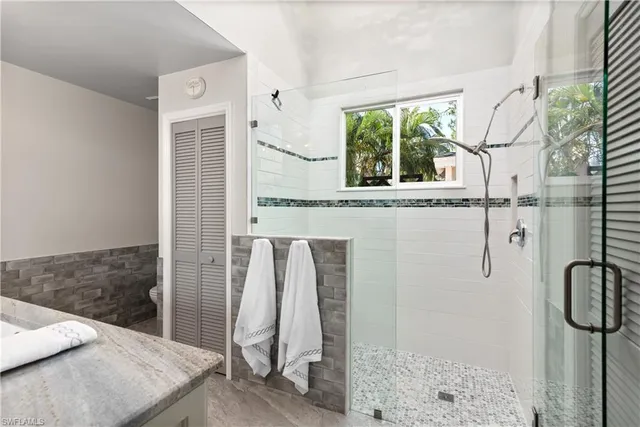 a bathroom with a granite countertop shower and a sink