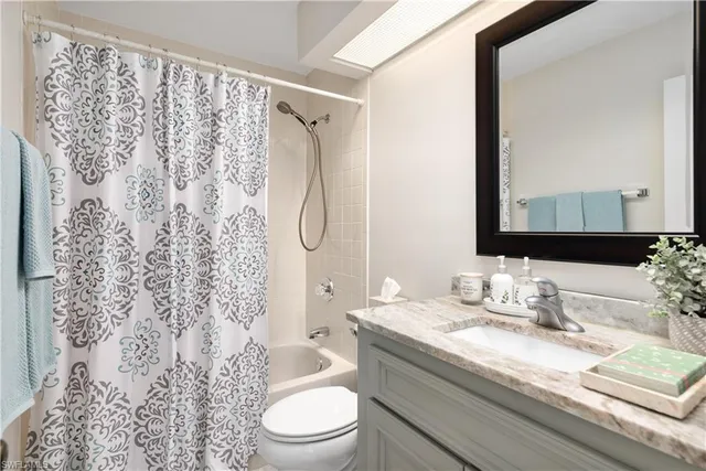 a bathroom with a granite countertop sink a toilet and a mirror