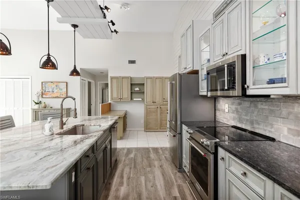 a kitchen with stainless steel appliances granite countertop a sink a stove and a refrigerator