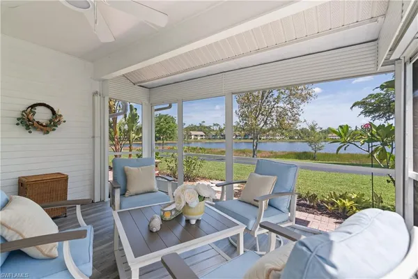 a living room with patio furniture and a floor to ceiling window