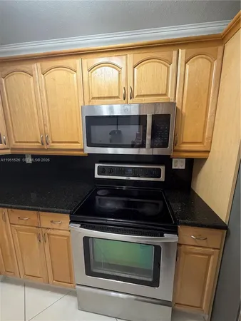 a kitchen with wooden cabinets and a stove top oven