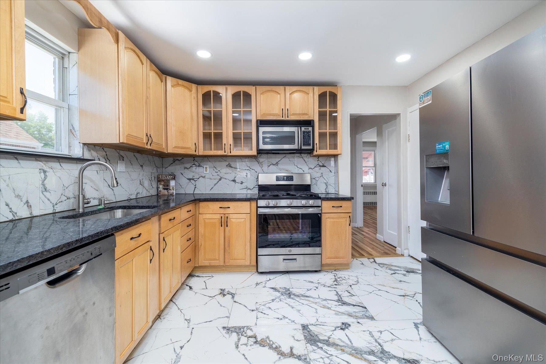 191 Raff Avenue Mineola, NY 11501 - Photo 13 of 25 a kitchen with stainless steel appliances granite countertop a stove a sink and a refrigerator