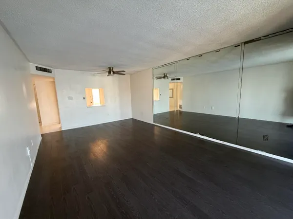 an empty room with wooden floor and windows