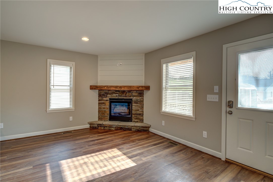142 Casey Overlook Lane, Unit 82 Boone, NC 28607 - Photo 20 of 43 an empty room with windows a fireplace and wooden floor