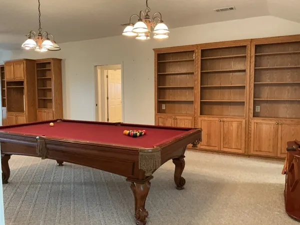 a room with pool table and windows