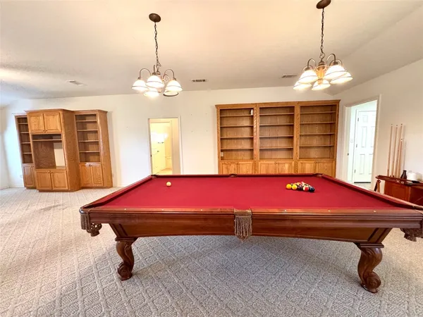 a living room with furniture and pool table
