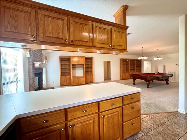 a kitchen with stainless steel appliances kitchen island granite countertop a stove a sink dishwasher and a microwave oven with large wooden cabinets