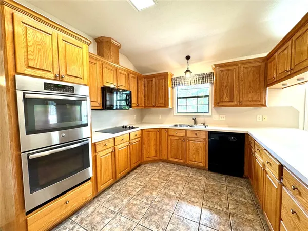 a view of an empty room and kitchen