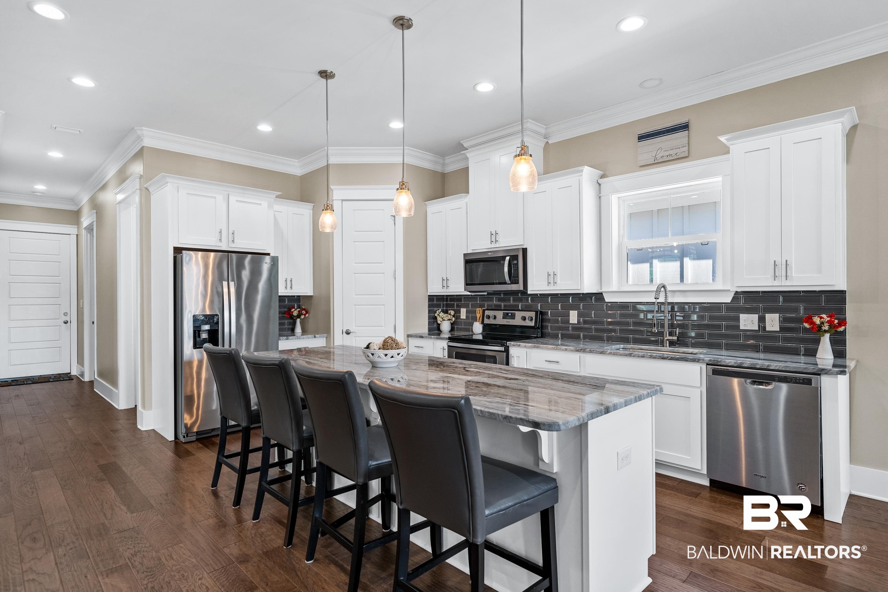 1018 Snapdragon Lane Foley, AL 36535 - Photo 13 of 37 Kitchen with white cabinetry, hanging light fixtures, a kitchen island, and stainless steel appliances