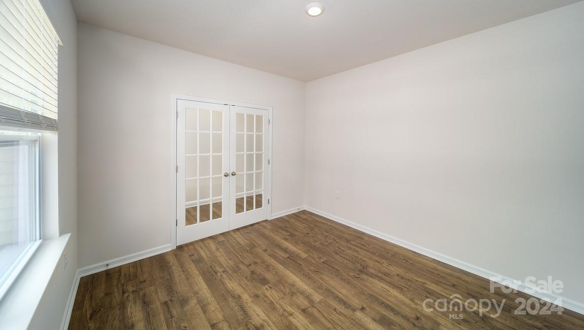 19 Dandelion Road Fletcher, NC 28732 - Photo 3 of 13 a view of an empty room with wooden floor and a window