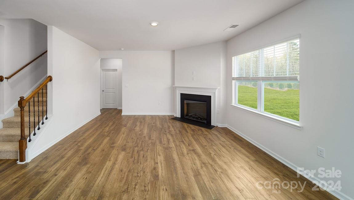 19 Dandelion Road Fletcher, NC 28732 - Photo 9 of 13 a view of empty room with wooden floor and fireplace