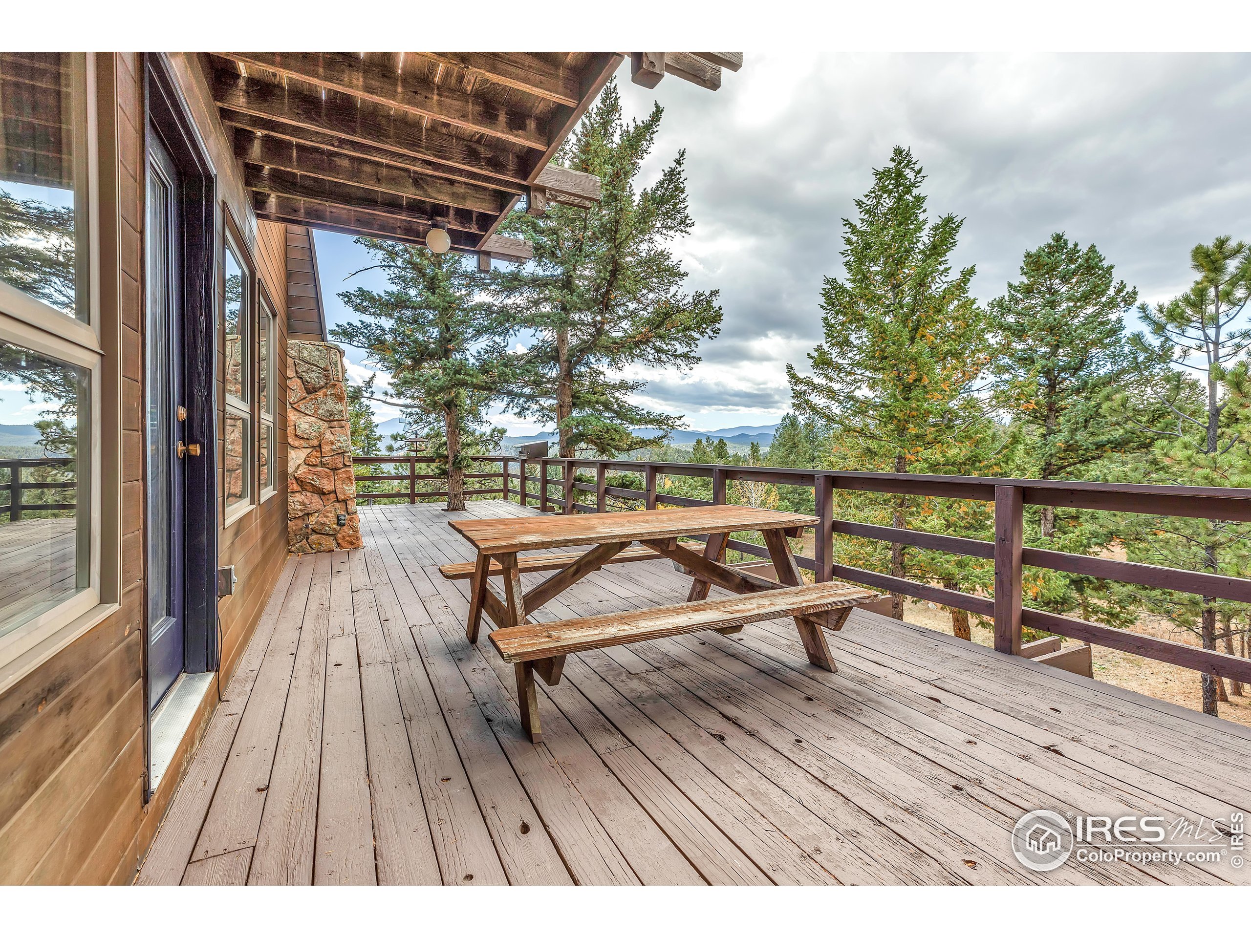 5566 Sugarloaf Road Boulder, CO 80302 - Photo 24 of 35 a view of wooden deck with a table and chairs