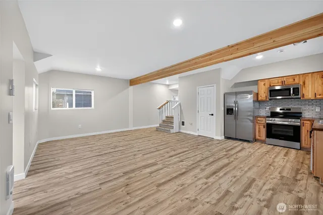 a kitchen with stainless steel appliances granite countertop a sink and wooden cabinets
