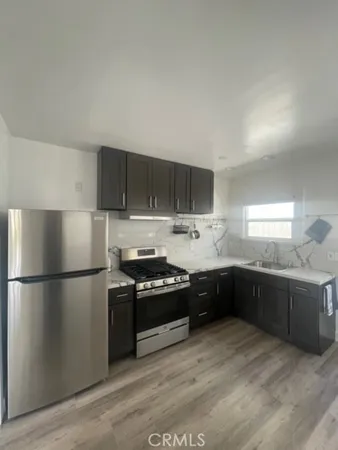 a kitchen with stainless steel appliances granite countertop a refrigerator a stove a sink and a microwave