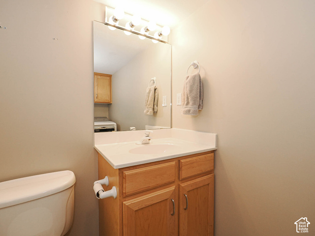 11779 South Stone Ridge Court Ridge West Riverton, UT 84065 - Photo 69 of 85 Bathroom vanity with a white countertop and integrated sink, complemented by natural wood-finish cabinetry