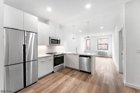 a kitchen with a refrigerator and a stove top oven