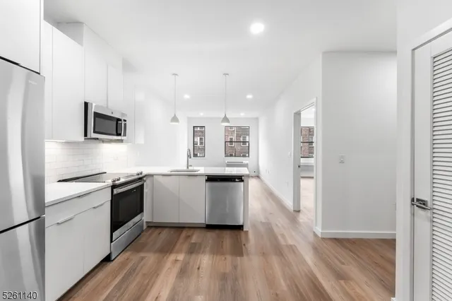 a kitchen with a refrigerator and a stove top oven