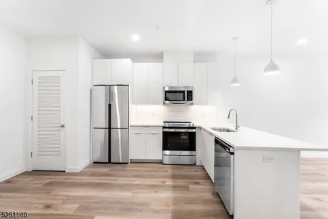 a kitchen with stainless steel appliances a stove refrigerator sink and microwave