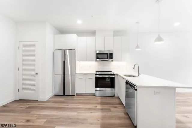 a kitchen with stainless steel appliances a stove refrigerator sink and microwave