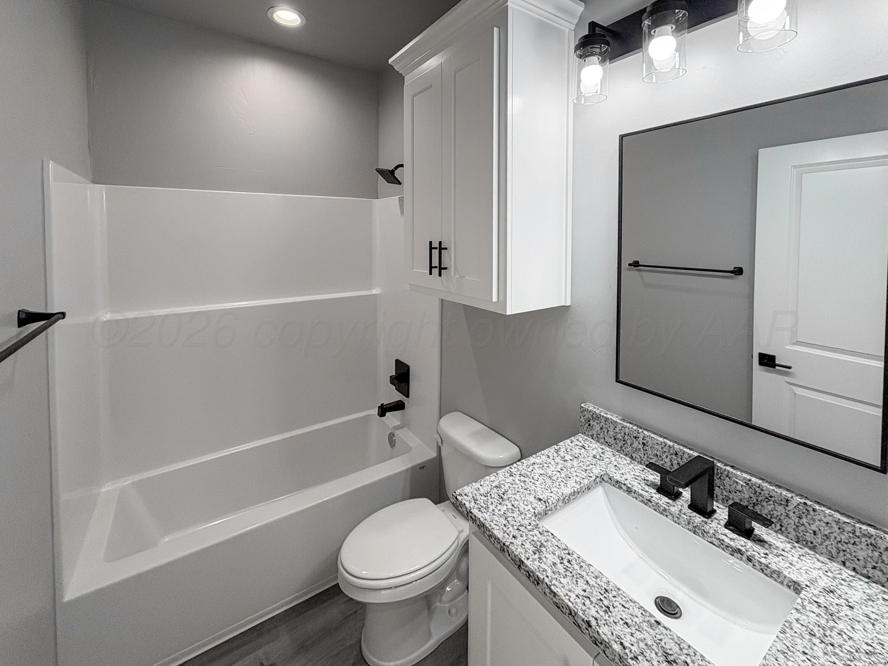 11074 Verano Drive Amarillo, TX 79119 - Photo 11 of 15 a bathroom with a granite countertop sink toilet and shower