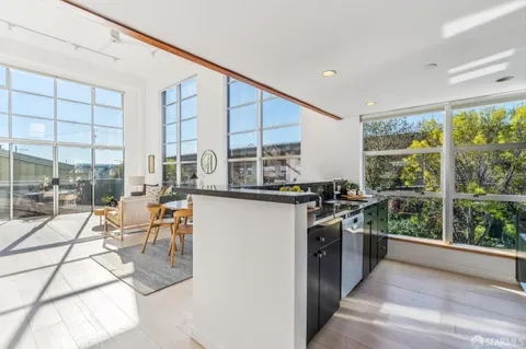 a view of a kitchen with kitchen island a large window cabinets and stainless steel appliances