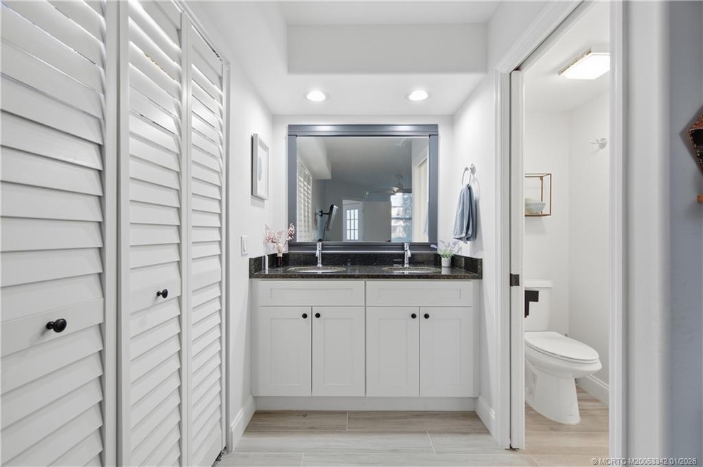 3584 Southwest Sunset Trace Circle Palm City, FL 34990 - Photo 15 of 32 a bathroom with a granite countertop sink mirror and a toilet