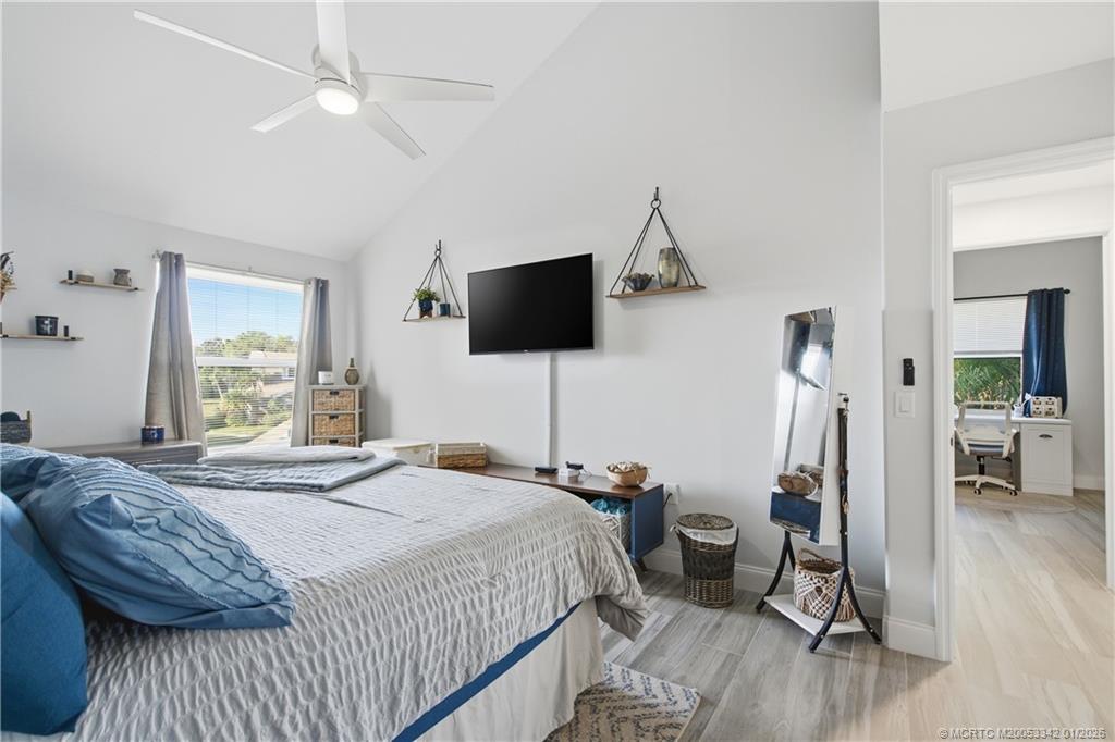 3584 Southwest Sunset Trace Circle Palm City, FL 34990 - Photo 20 of 32 a bedroom with a bed and a flat screen tv