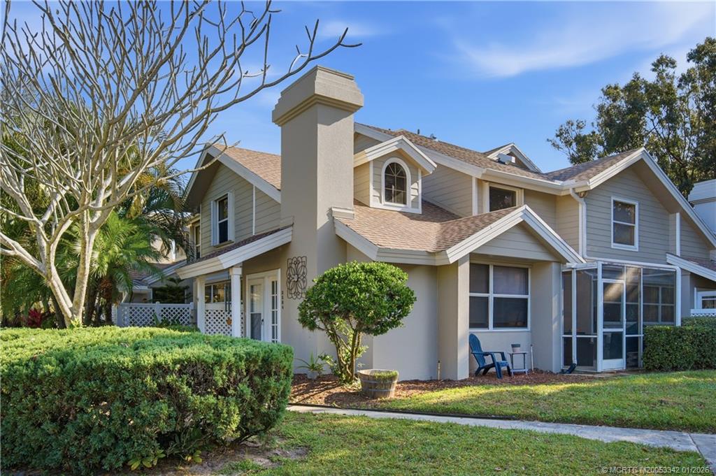 3584 Southwest Sunset Trace Circle Palm City, FL 34990 - Photo 23 of 32 a front view of a house with a garden and yard