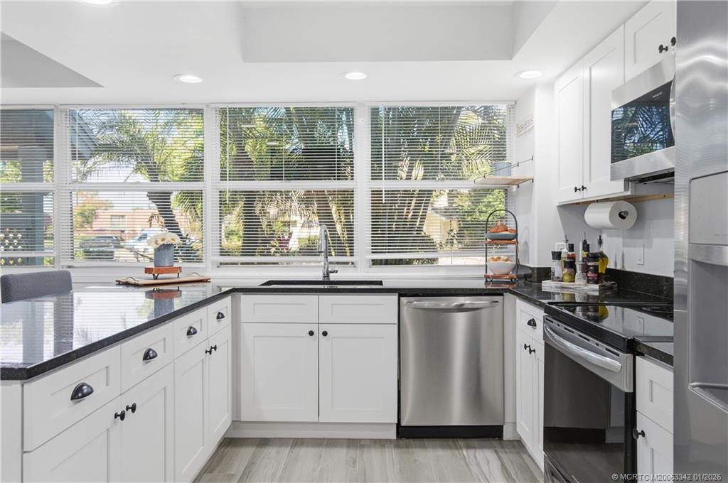 3584 Southwest Sunset Trace Circle Palm City, FL 34990 - Photo 8 of 32 a kitchen with a sink stove and cabinets