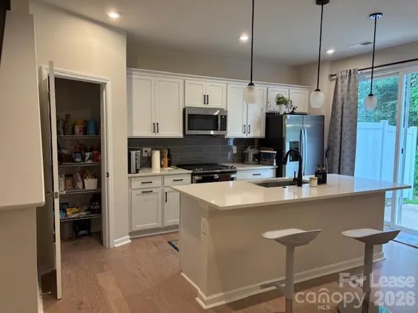 a kitchen that has a lot of cabinets and refrigerator in it