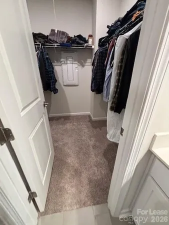 a view of walk in closet with clothes and shoes