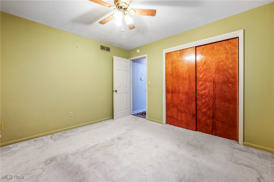 844 Roseland Road Alliance, OH 44601 - Photo 26 of 40 Unfurnished bedroom featuring a closet, ceiling fan, and light carpet