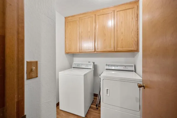 a backyard of a house with large trees and outdoor seating