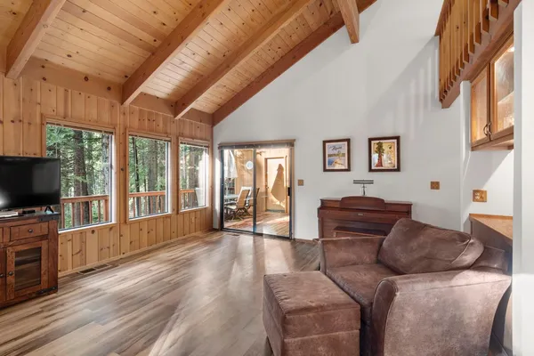 a dining room with furniture a chandelier and wooden floor