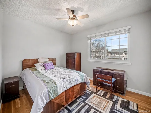 a bedroom with a bed a dresser and a chandelier