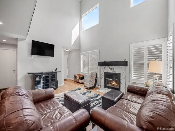 a living room with furniture a fireplace and a flat screen tv