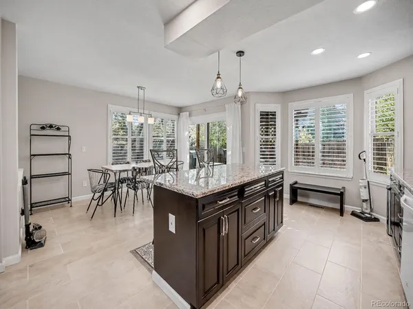 an open kitchen with granite countertop a stove and a sink