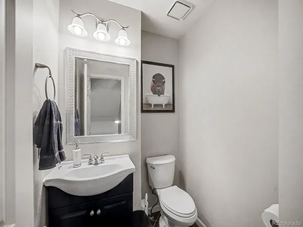a bathroom with a toilet a sink and mirror
