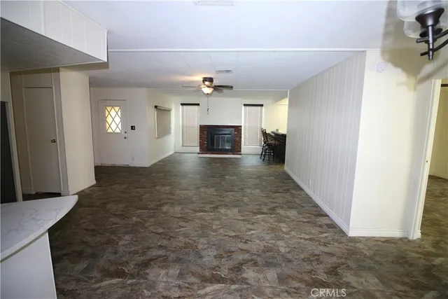 a view of a hallway with wooden floor and a kitchen