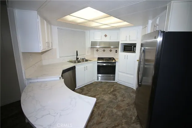 a kitchen with stainless steel appliances a refrigerator and a sink