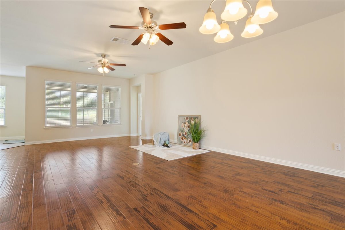 108 Cathedral Mountain Pass Georgetown, TX 78633 - Photo 8 of 36 a view of an empty room with wooden floor and a window