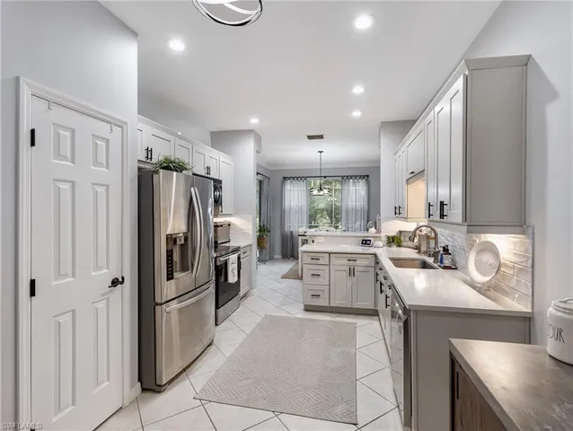 a kitchen with a sink appliances and cabinets