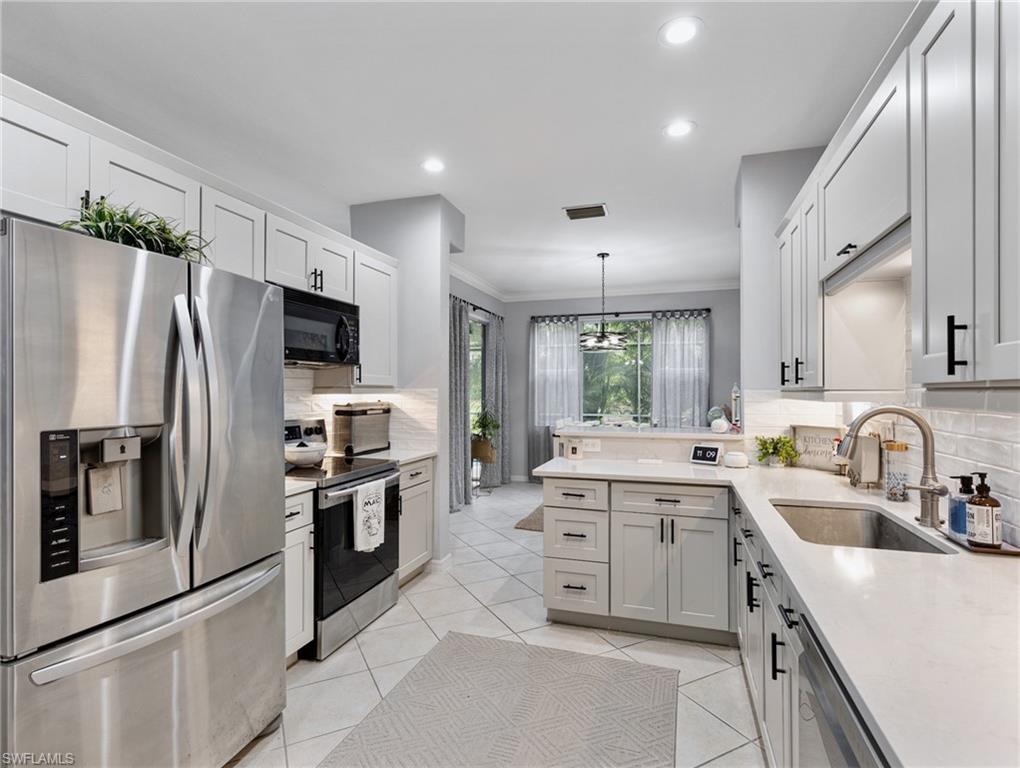 20334 Larino Loop Estero, FL 33928 - Photo 15 of 39 a kitchen with a sink stove and refrigerator