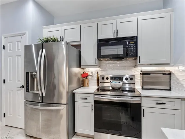 a kitchen with cabinets stainless steel appliances and a counter space