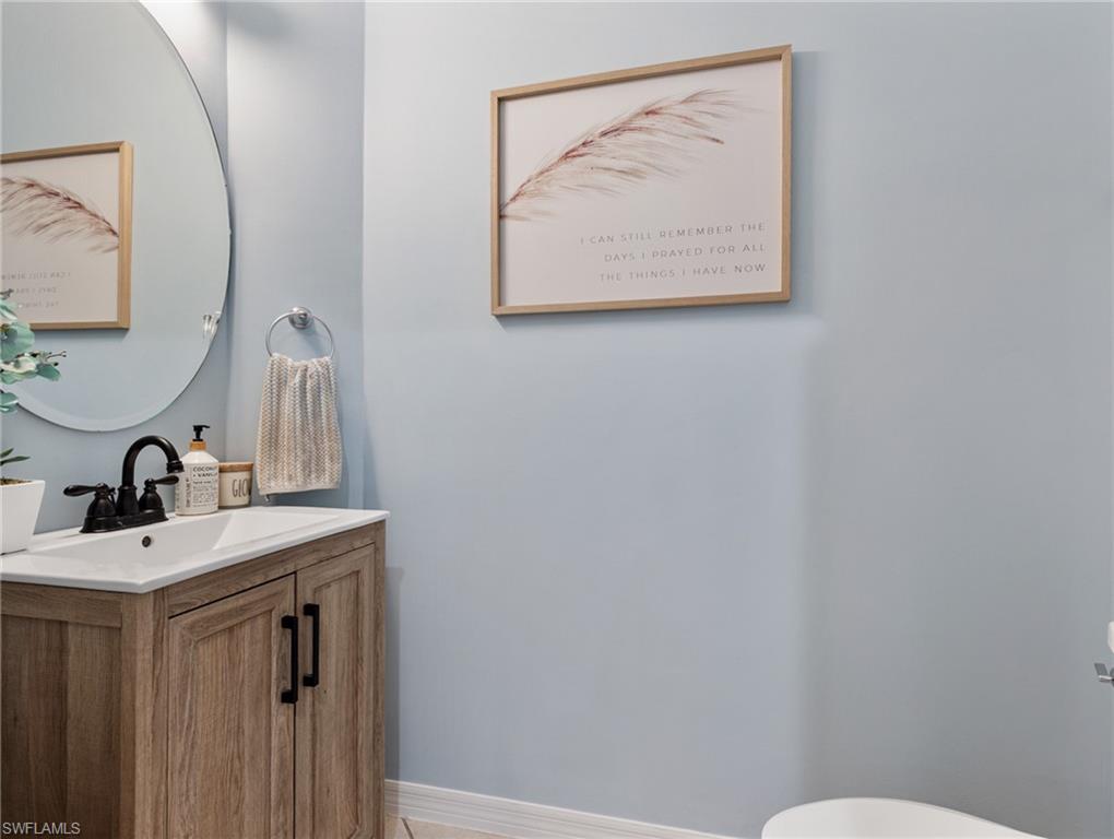 20334 Larino Loop Estero, FL 33928 - Photo 20 of 39 a bathroom with a sink a toilet and mirror