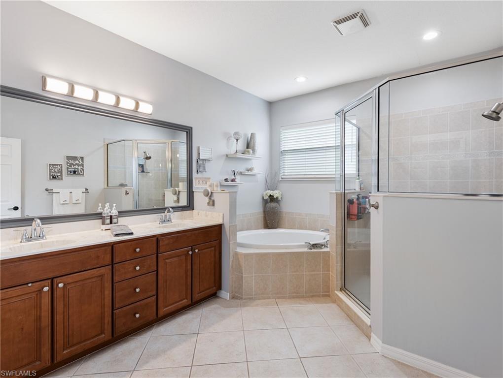20334 Larino Loop Estero, FL 33928 - Photo 27 of 39 a spacious bathroom with a double vanity sink mirror and bathtub