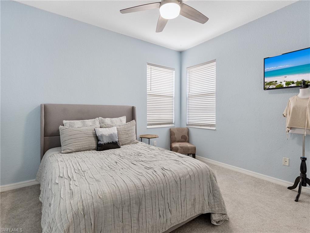 20334 Larino Loop Estero, FL 33928 - Photo 32 of 39 a bedroom with a bed and a chandelier